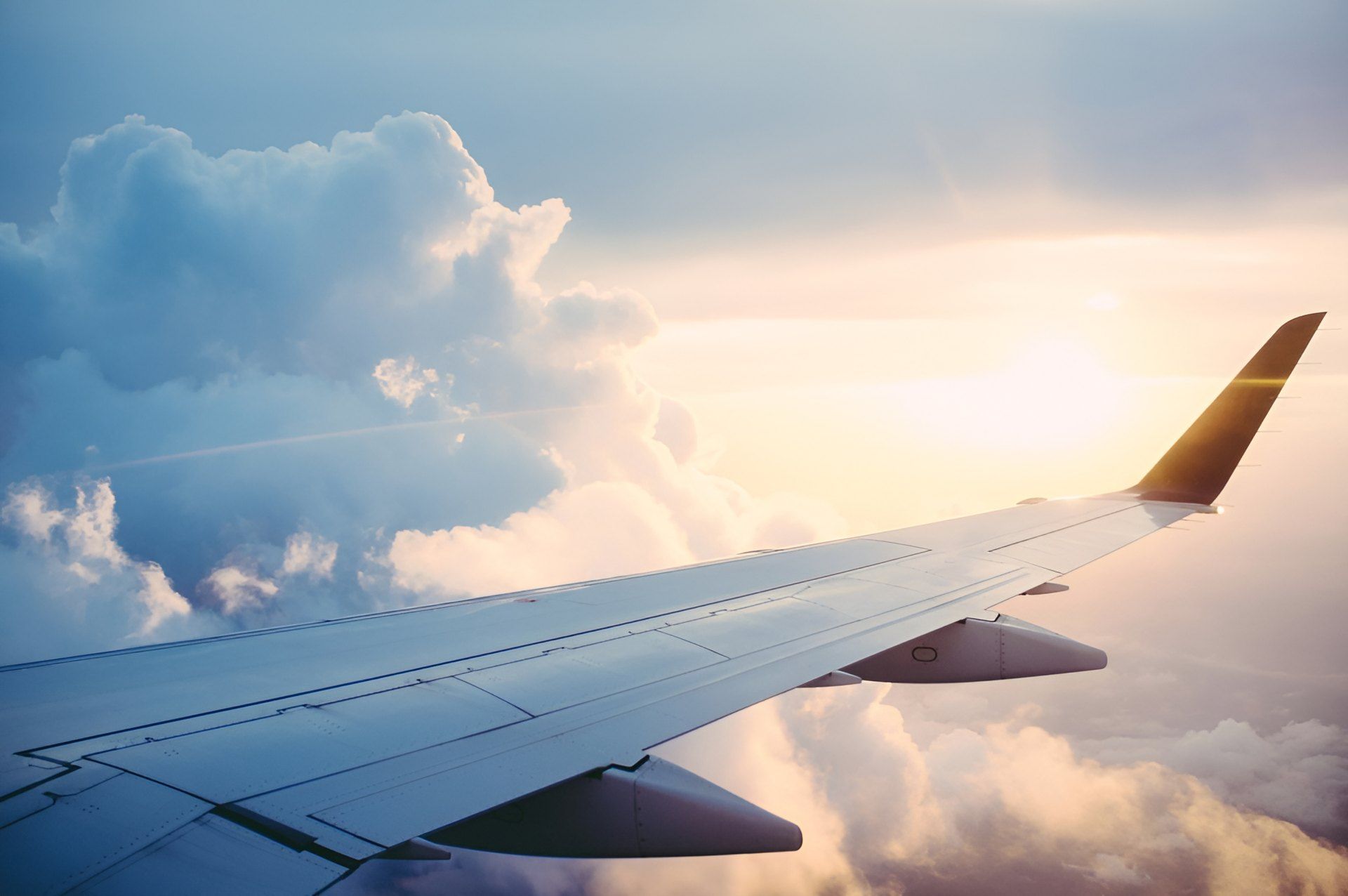 Aircraft wing above the clouds at sunrise